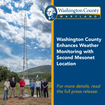 Weather tower with mesonet team posed in front of it